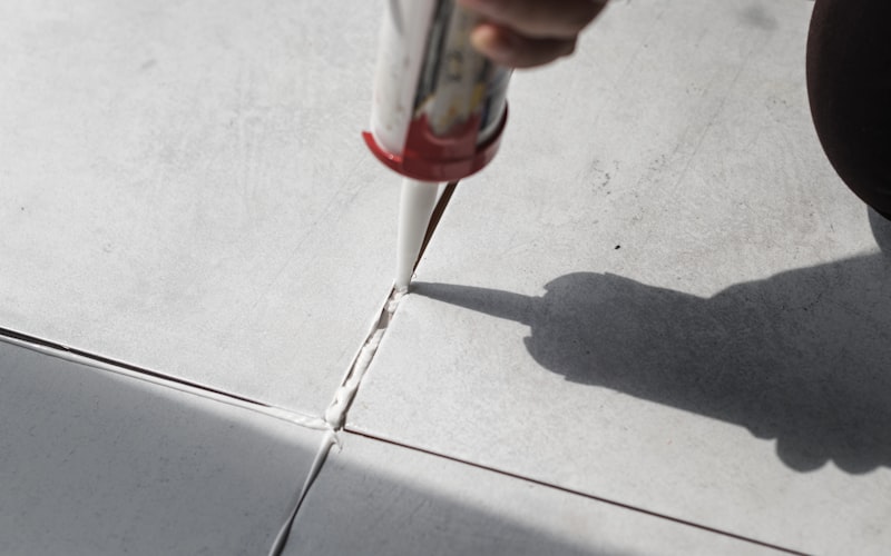 Close-up of steam mop cleaning grout between tiles