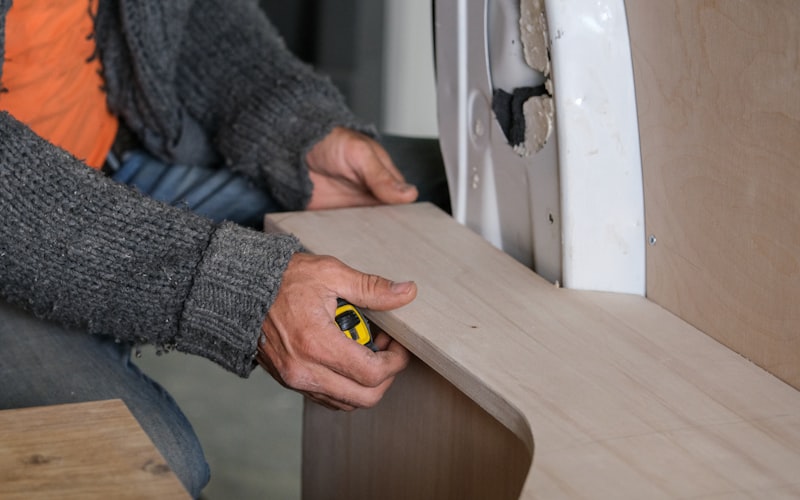 A freshly built wooden raised garden bed sitting on level ground in a sunny backyard, ready to be filled with soil