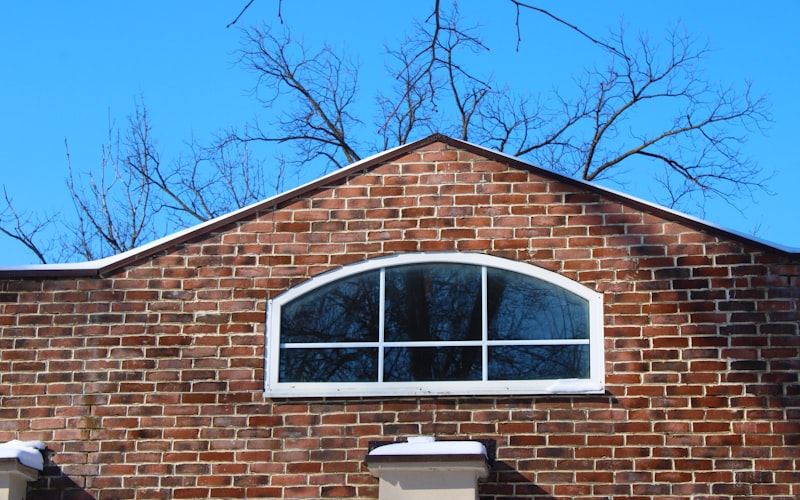 Close-up of fresh weatherstripping being applied along the side channel of a double-hung window sash