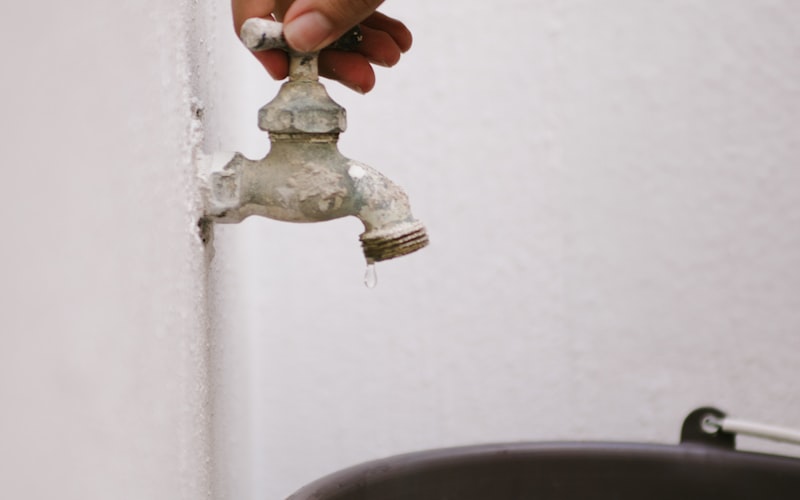 Close-up of hands adjusting the float mechanism inside a toilet tank
