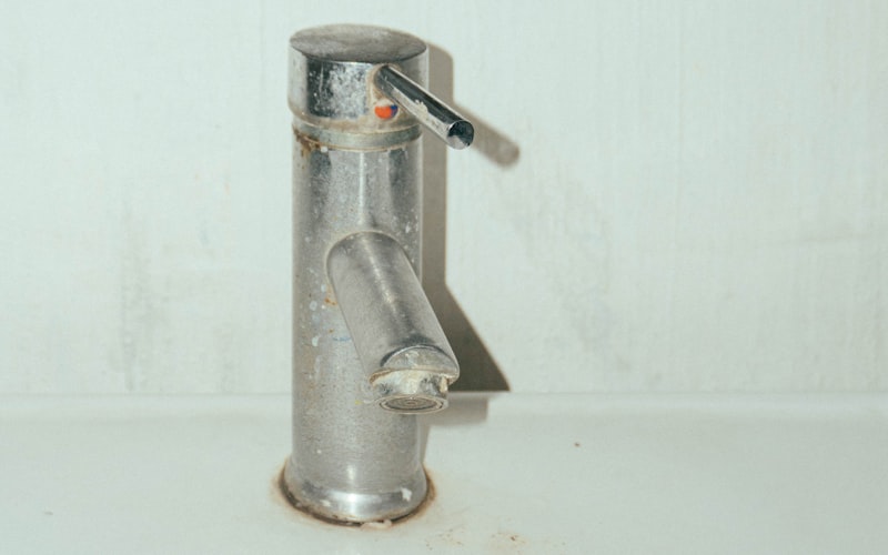 Drain snake tool being used to clear a clogged sink drain