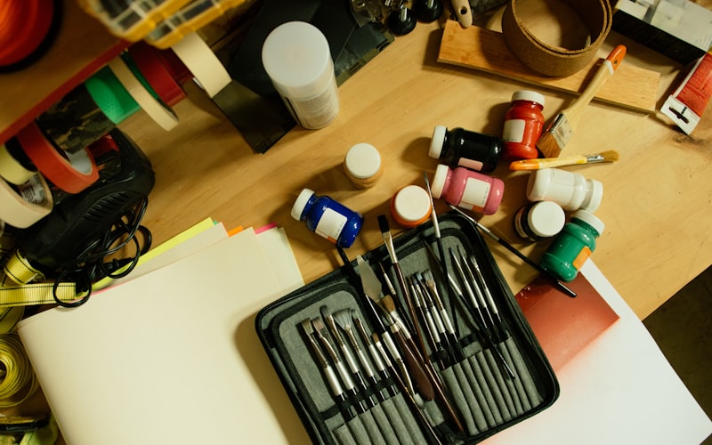 An overhead view of a messy junk drawer filled with assorted items, batteries, pens, and random objects