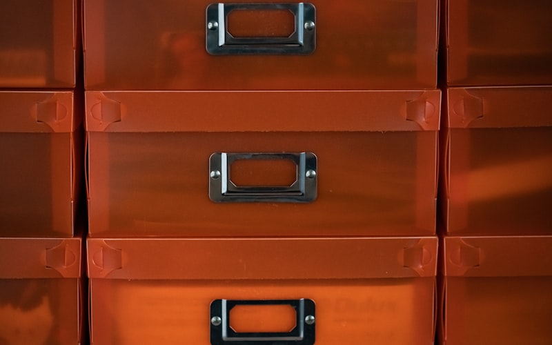 A neatly organized junk drawer with labeled compartments containing scissors, tape, batteries, and pens
