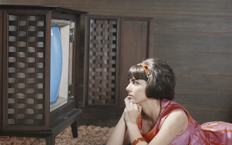 A living room TV screen showing a streaming service menu with a remote control on the coffee table