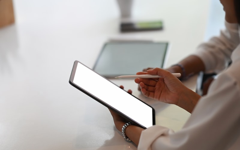 A comparison chart on a tablet screen showing streaming service prices for ad-supported vs premium tiers